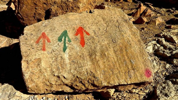 Wegweiser gemalt auf Versteinerungen im Tal bei Timezguida, Foto: marokko-erfahren.de